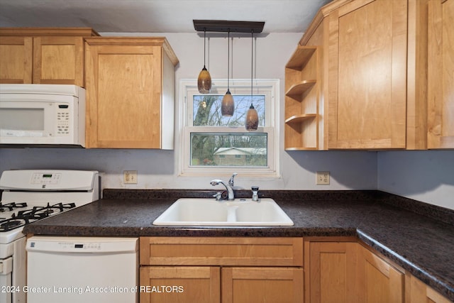 kitchen featuring decorative light fixtures, white appliances, and sink