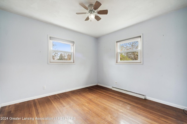 empty room with hardwood / wood-style floors, ceiling fan, and a baseboard radiator