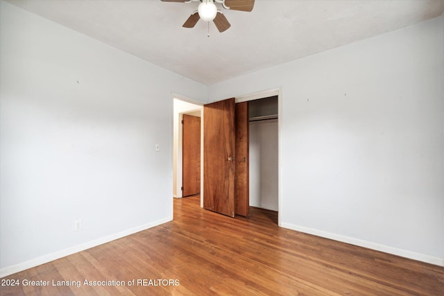 unfurnished bedroom featuring hardwood / wood-style floors, ceiling fan, and a closet