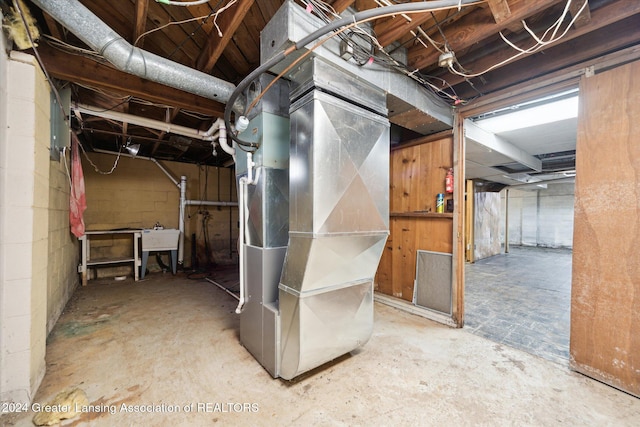 basement with heating unit and sink