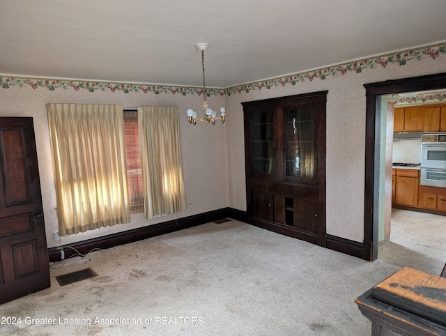 unfurnished dining area with light carpet and an inviting chandelier