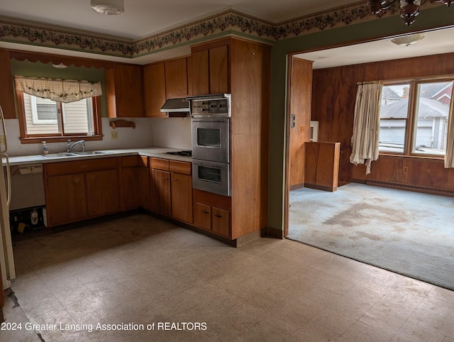 kitchen with gas stovetop, double oven, plenty of natural light, and sink