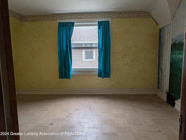 spare room featuring vaulted ceiling