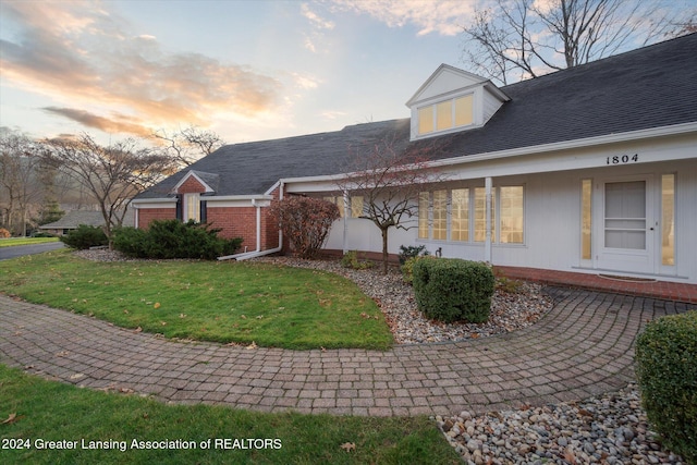 property exterior at dusk with a yard