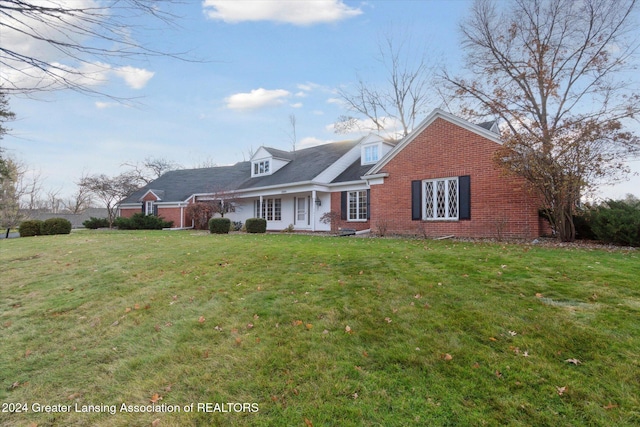 cape cod-style house with a front lawn