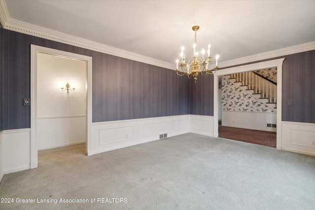 empty room featuring carpet floors, an inviting chandelier, and crown molding