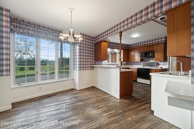 kitchen with an inviting chandelier, electric stove, decorative light fixtures, dark hardwood / wood-style flooring, and kitchen peninsula