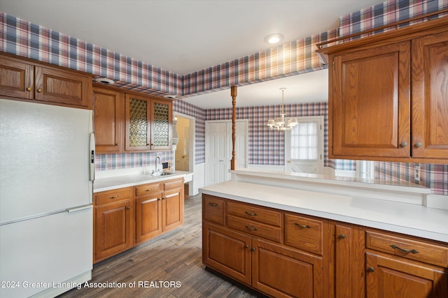 kitchen with tasteful backsplash, sink, white refrigerator, an inviting chandelier, and hardwood / wood-style floors