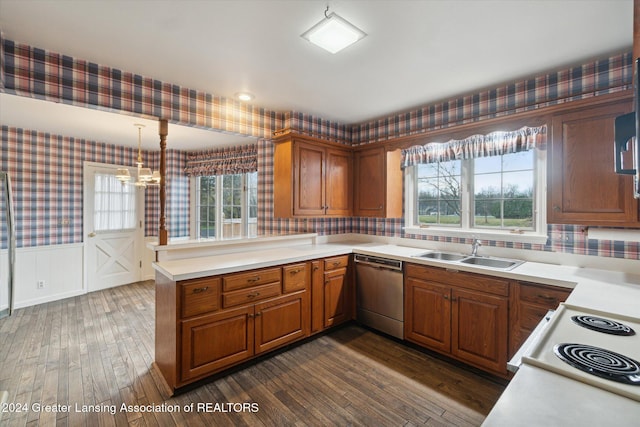 kitchen featuring dishwasher, sink, dark wood-type flooring, kitchen peninsula, and decorative light fixtures