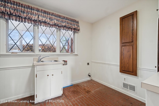 laundry room featuring hookup for an electric dryer, cabinets, and sink