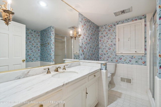 bathroom with walk in shower, vanity, tile walls, tile patterned flooring, and toilet