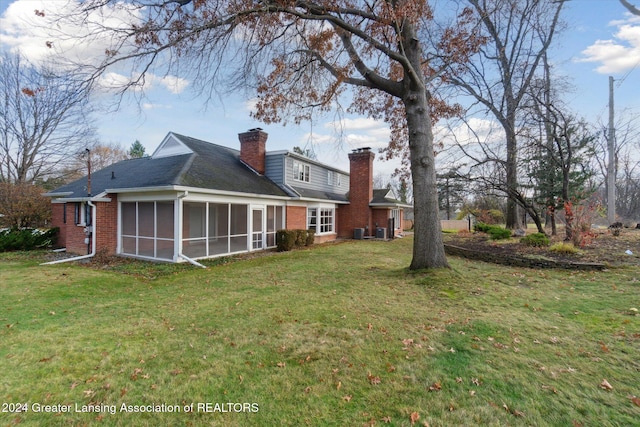 back of house featuring a lawn, cooling unit, and a sunroom