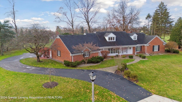 cape cod house with a front yard