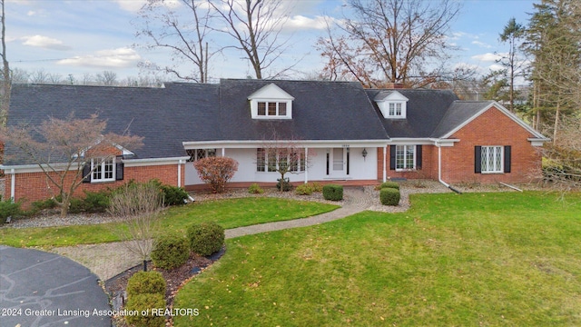 new england style home featuring a front lawn