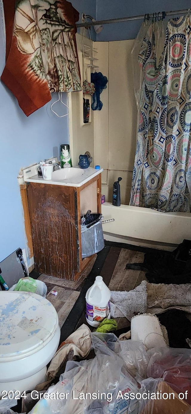 full bathroom with shower / bath combo with shower curtain, sink, and toilet