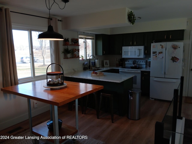 kitchen with dark hardwood / wood-style floors, sink, decorative light fixtures, and white appliances