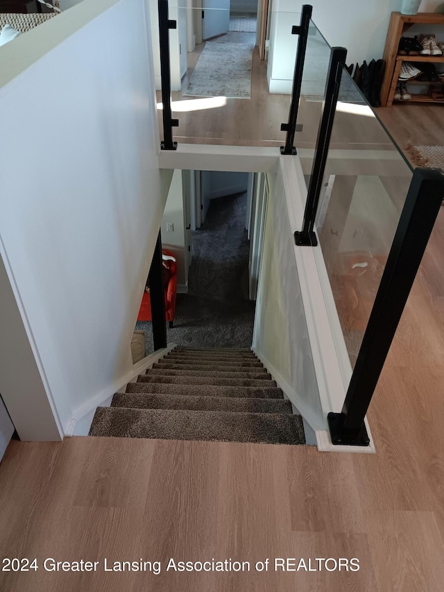 staircase with hardwood / wood-style flooring