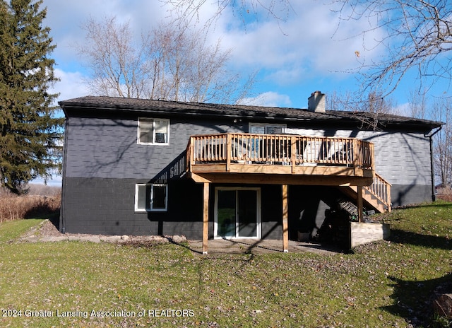 back of house with a deck and a yard