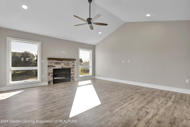 unfurnished living room featuring hardwood / wood-style flooring, ceiling fan, a healthy amount of sunlight, and a fireplace