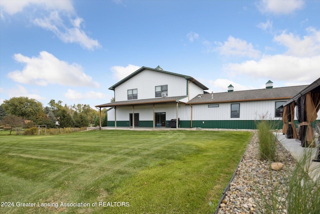 rear view of property with a yard and a patio