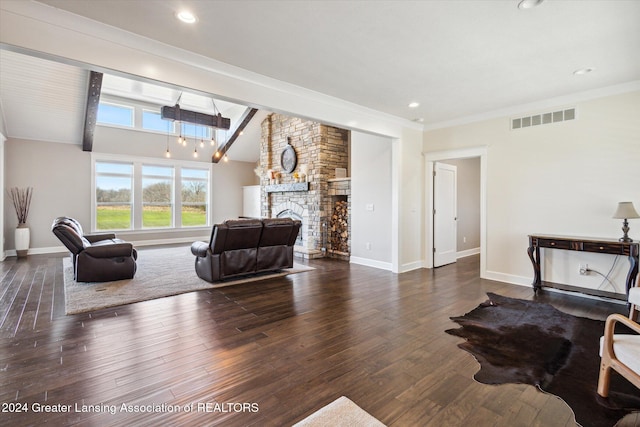 living room featuring vaulted ceiling with beams, crown molding, dark hardwood / wood-style flooring, and a stone fireplace