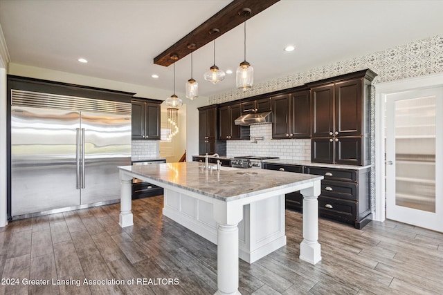 kitchen with backsplash, wood-type flooring, stainless steel appliances, and a breakfast bar area