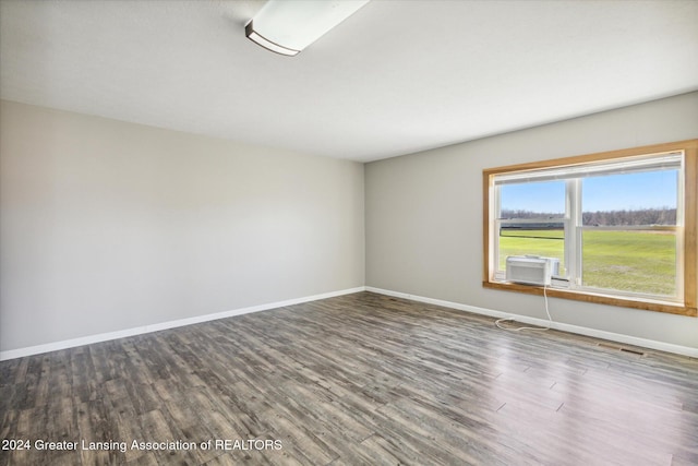 empty room with dark hardwood / wood-style floors and cooling unit