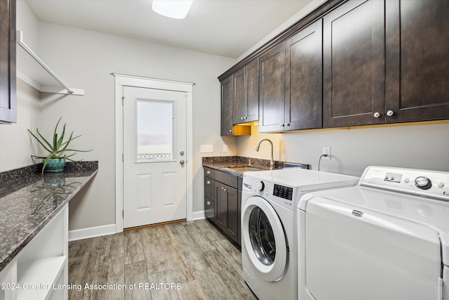 washroom featuring cabinets, independent washer and dryer, light wood-type flooring, and sink