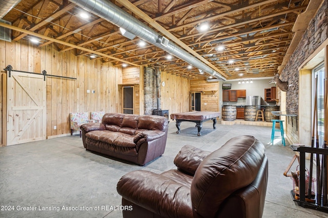 living room featuring wood walls, a barn door, and pool table