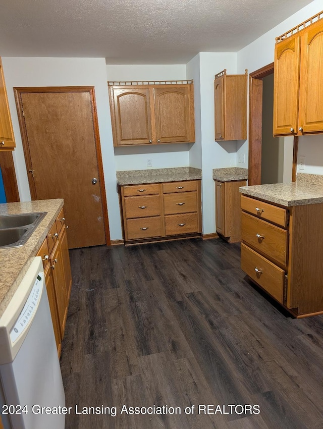 kitchen with a textured ceiling, dark hardwood / wood-style floors, dishwasher, and sink