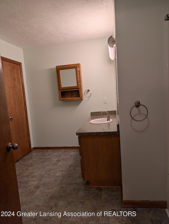 bathroom featuring a textured ceiling and vanity