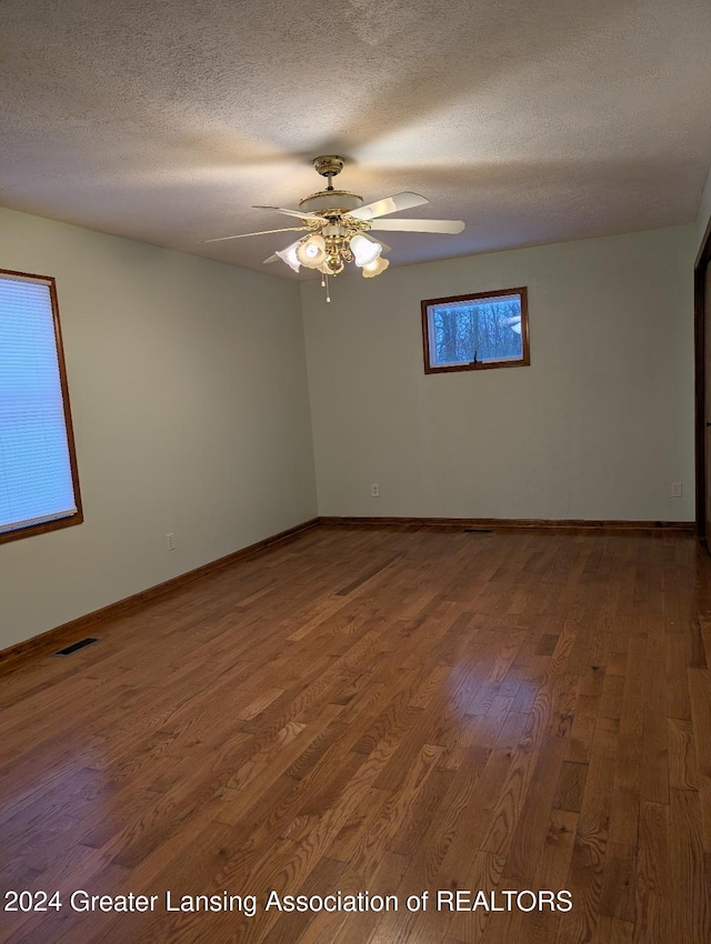 spare room with ceiling fan, hardwood / wood-style floors, and a textured ceiling