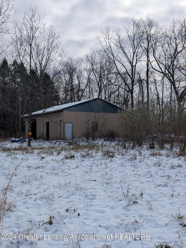 view of snow covered exterior featuring an outdoor structure