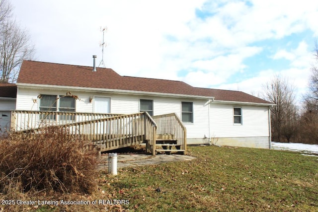 back of house with a deck, a yard, and roof with shingles