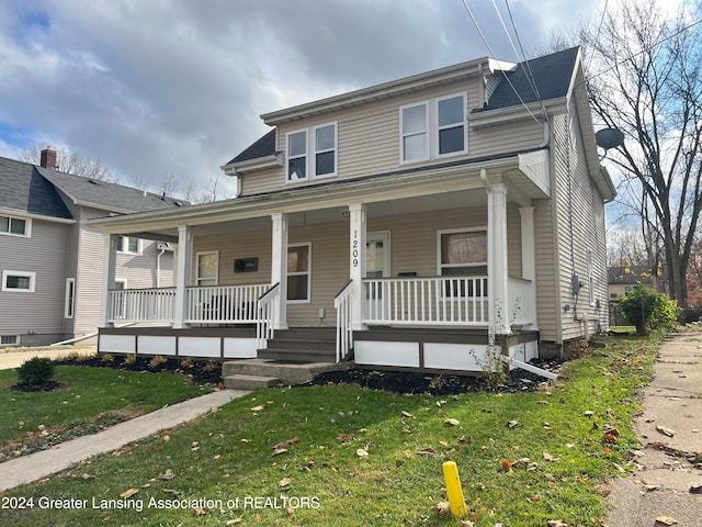 view of front facade featuring covered porch and a front lawn