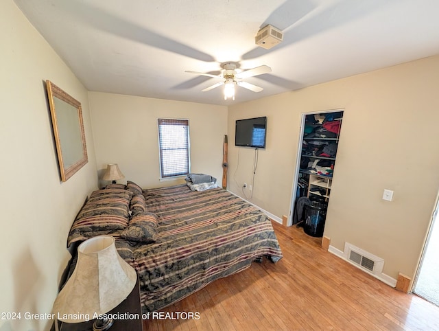 bedroom featuring ceiling fan, light hardwood / wood-style floors, a spacious closet, and a closet