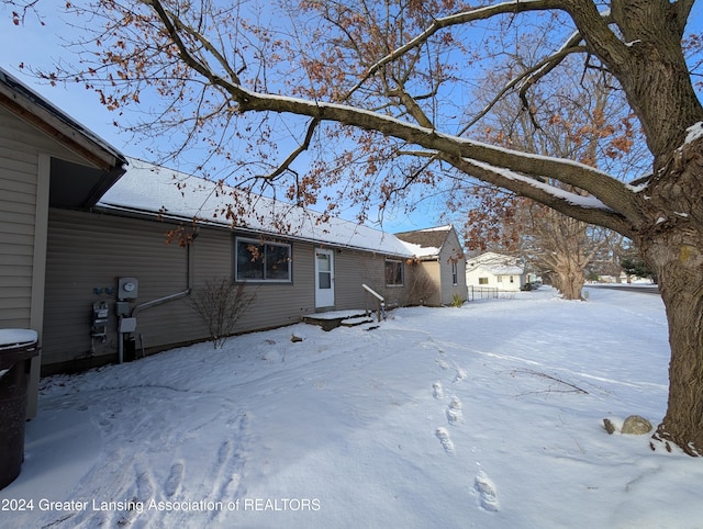 view of snow covered rear of property