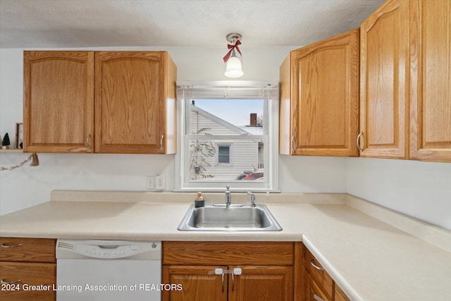 kitchen featuring white dishwasher, sink, and a textured ceiling