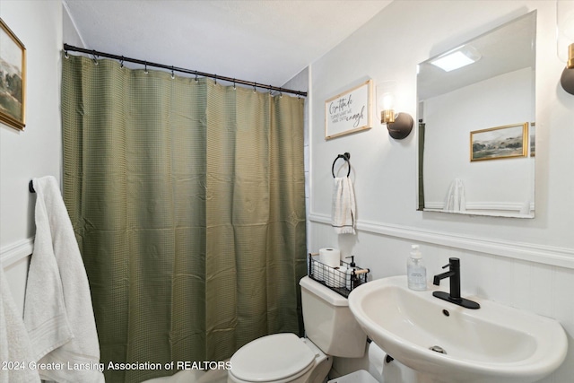 bathroom with a shower with curtain, toilet, and sink