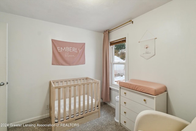 carpeted bedroom featuring a nursery area