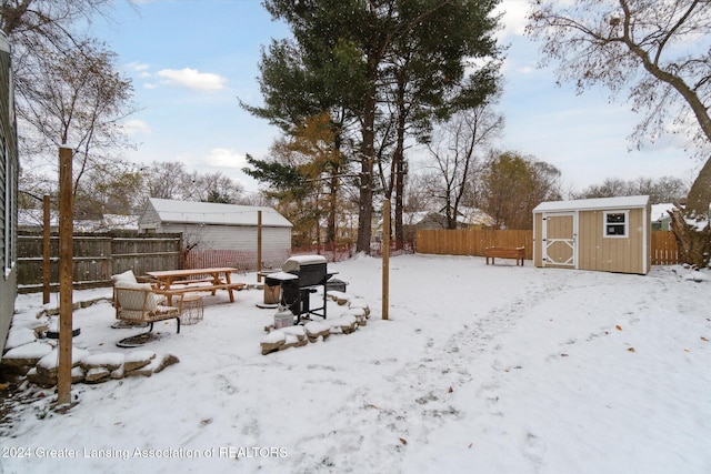 yard covered in snow with a shed