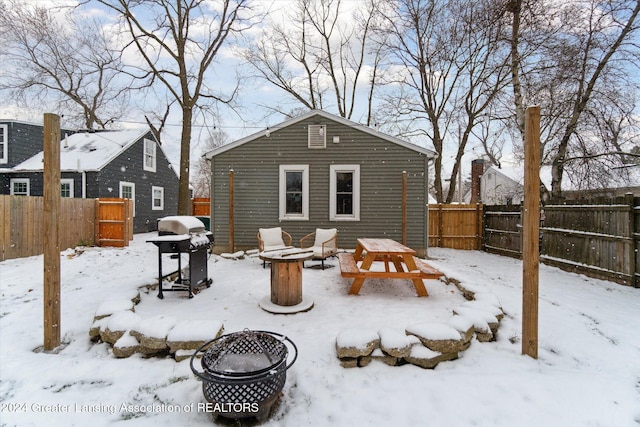 snow covered property featuring an outdoor fire pit