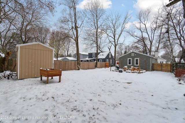 yard layered in snow with a storage shed