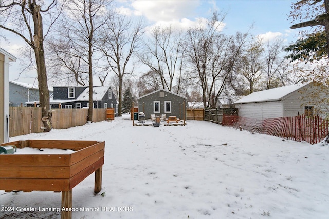 snowy yard featuring an outdoor structure