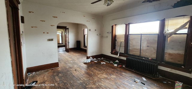 spare room with radiator heating unit, dark hardwood / wood-style floors, and ceiling fan