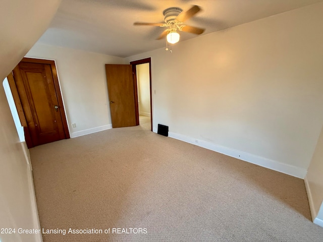 empty room featuring ceiling fan and light carpet