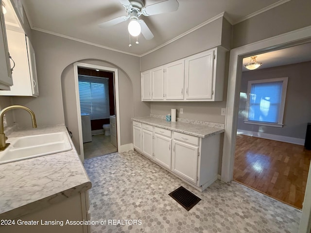 kitchen with sink, ceiling fan, ornamental molding, light hardwood / wood-style floors, and white cabinetry