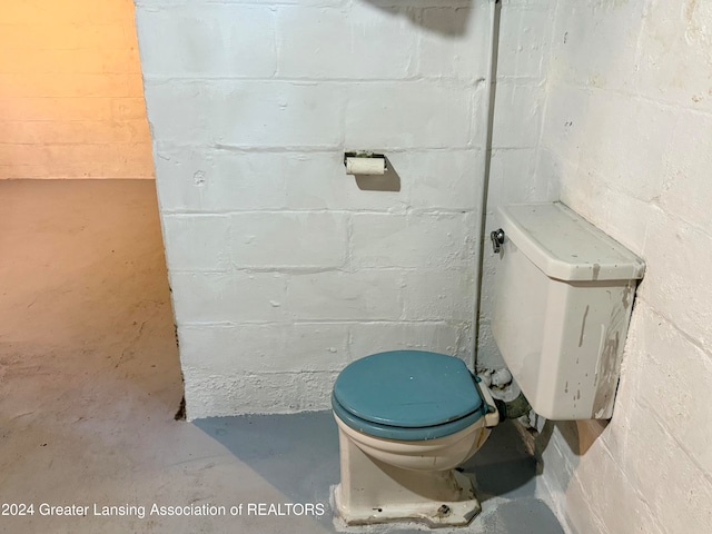 bathroom with concrete floors and toilet