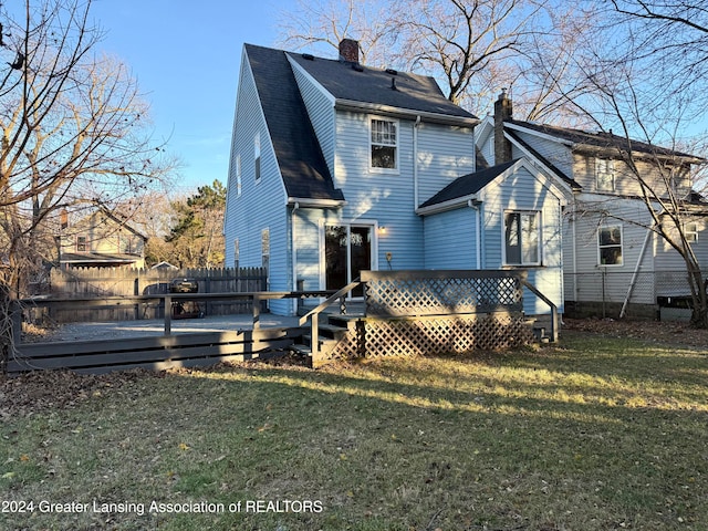 rear view of property with a lawn and a deck