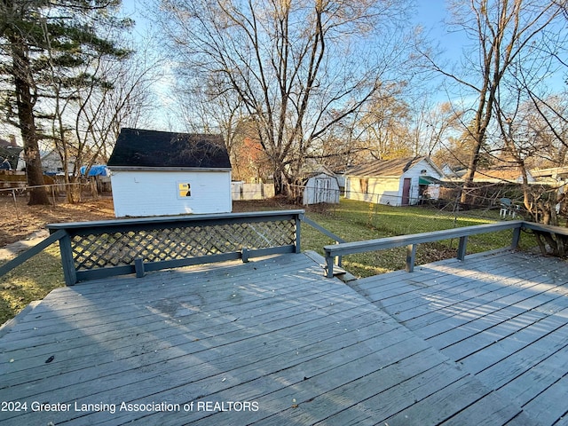 deck with a lawn and a storage shed